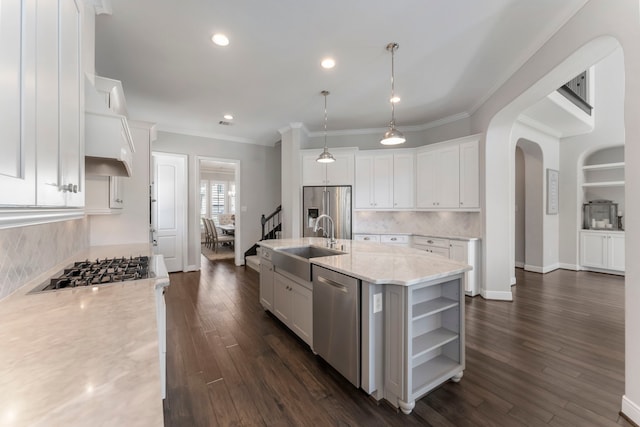 kitchen featuring a sink, stainless steel appliances, arched walkways, white cabinetry, and open shelves