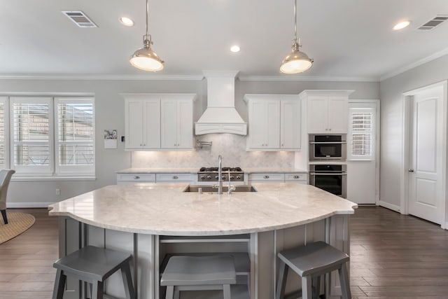 kitchen with custom exhaust hood, visible vents, crown molding, and a sink