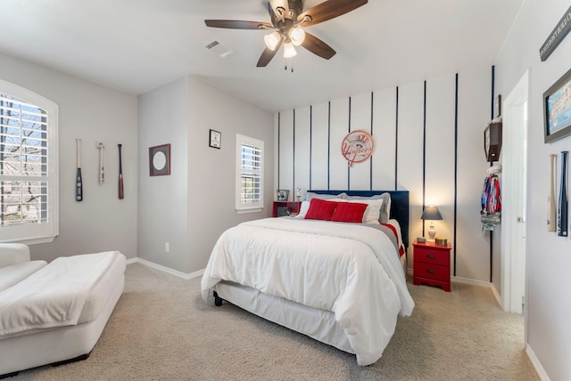 carpeted bedroom featuring visible vents, baseboards, and a ceiling fan