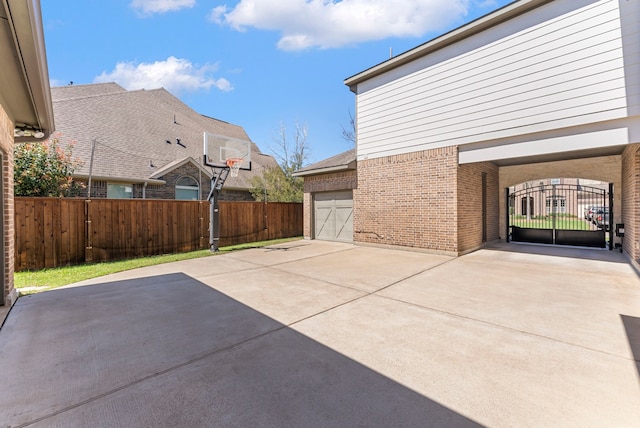 view of patio / terrace featuring a gate, driveway, a garage, and fence