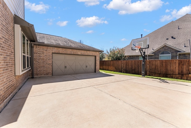 view of patio featuring a garage, driveway, and fence