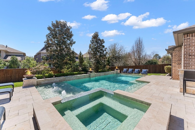 view of pool featuring a fenced backyard, a pool with connected hot tub, and a patio