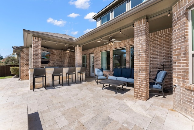 view of patio / terrace with outdoor dry bar, an outdoor living space, and ceiling fan