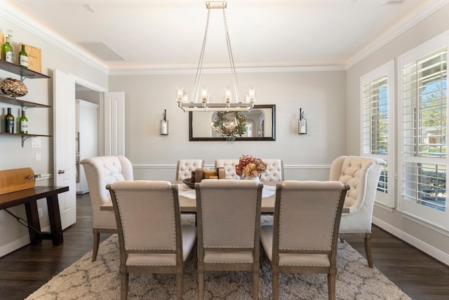 dining area with baseboards, dark wood-type flooring, an inviting chandelier, and crown molding