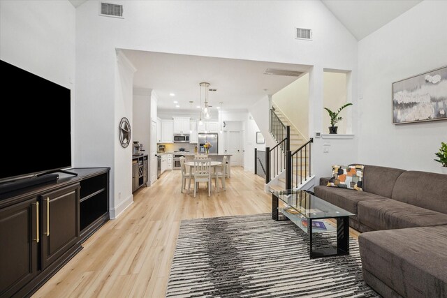 727 Dorothy St, Houston, TX 77007 - living area featuring stairs, light wood-type flooring, baseboards, high vaulted ceiling, and recessed lighting