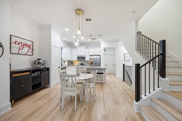 727 Dorothy St, Houston, TX 77007 - dining area featuring crown molding, light wood finished floors, stairway, recessed lighting, and baseboards
