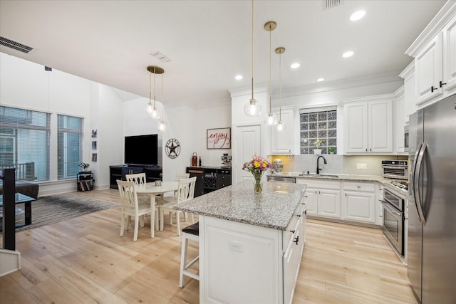 727 Dorothy St, Houston, TX 77007 - kitchen featuring appliances with stainless steel finishes, a sink, white cabinets, backsplash, and recessed lighting