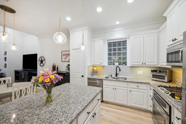 727 Dorothy St, Houston, TX 77007 - kitchen with stainless steel appliances, a sink, crown molding, white cabinetry, and tasteful backsplash