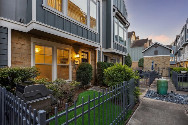 727 Dorothy St, Houston, TX 77007 - exterior entry at dusk featuring board and batten siding, fence, and a residential view