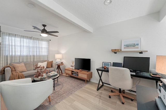 office area featuring baseboards, beamed ceiling, wood finished floors, a textured ceiling, and a ceiling fan