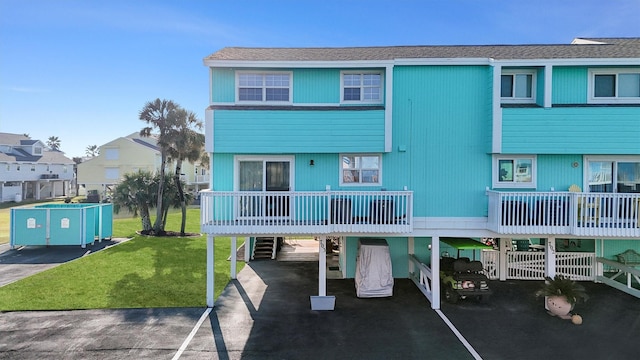 view of front of property featuring a carport, a front lawn, and driveway