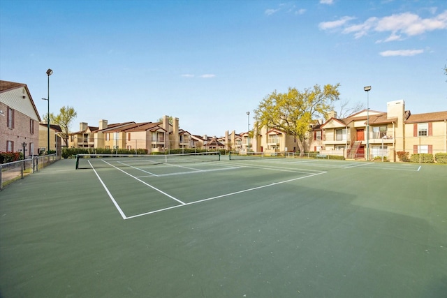 view of sport court with fence and a residential view