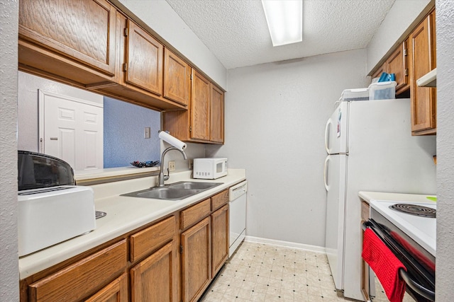 kitchen featuring white appliances, brown cabinetry, light floors, a sink, and light countertops