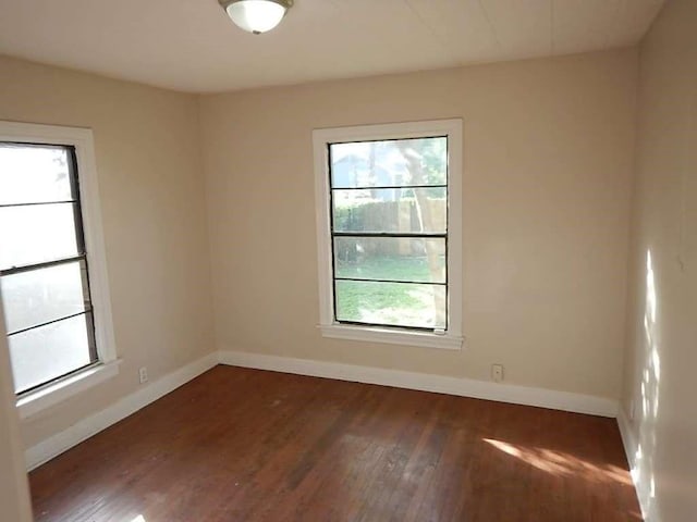 empty room with baseboards and wood finished floors