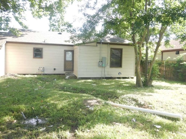 back of house featuring a lawn and fence