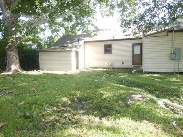 rear view of house featuring a lawn