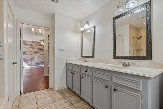 bathroom with double vanity, visible vents, and a sink