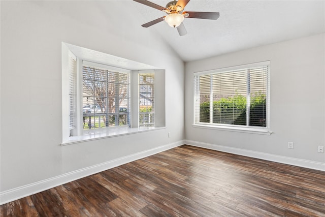 empty room with vaulted ceiling, ceiling fan, baseboards, and wood finished floors