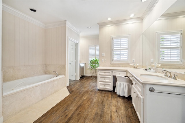 bathroom with wood-type flooring, a garden tub, a healthy amount of sunlight, and vanity