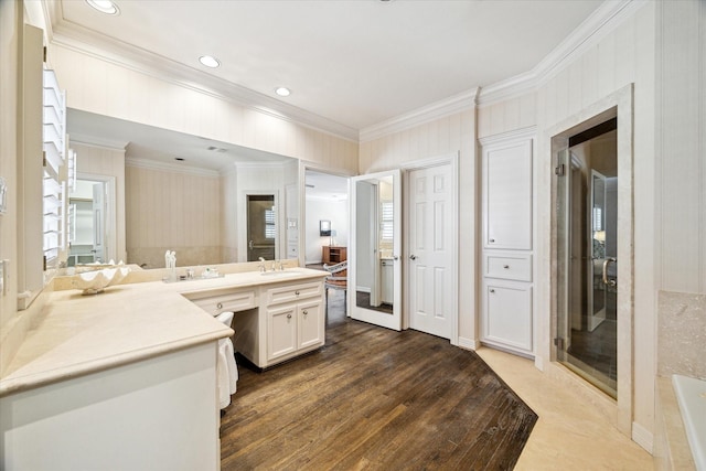 full bath with a tub, wood finished floors, recessed lighting, crown molding, and vanity