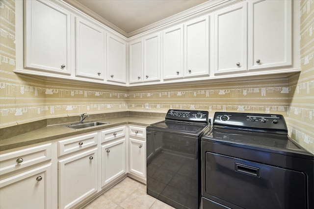 laundry room with a sink, washing machine and dryer, cabinet space, wallpapered walls, and light tile patterned floors