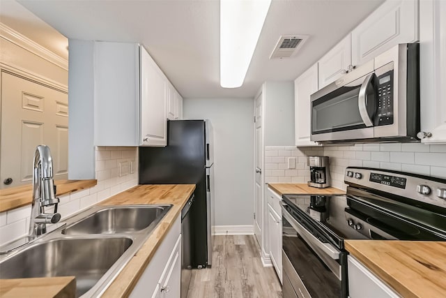 kitchen with a sink, stainless steel appliances, and butcher block counters