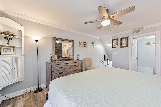 bedroom with a ceiling fan, wood finished floors, visible vents, baseboards, and crown molding