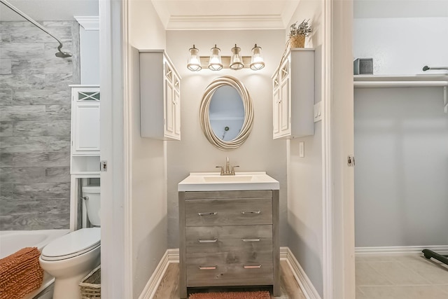 bathroom with tile patterned flooring, crown molding, baseboards, toilet, and vanity