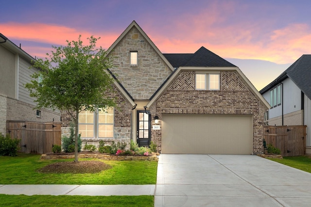 view of front of house with a lawn, fence, concrete driveway, a garage, and brick siding