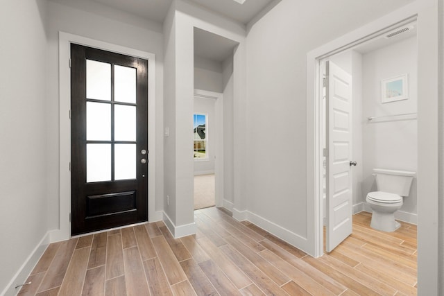 foyer with visible vents, baseboards, and wood tiled floor