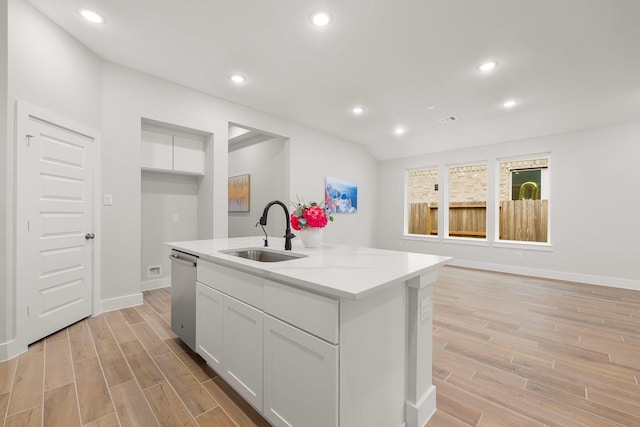 kitchen with a sink, stainless steel dishwasher, recessed lighting, white cabinets, and wood tiled floor