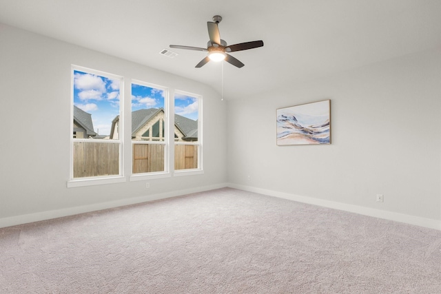 carpeted spare room with baseboards, visible vents, and ceiling fan