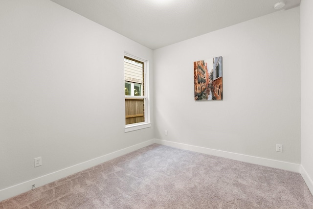 empty room with baseboards and carpet flooring