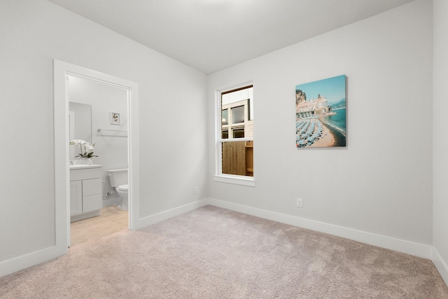 empty room with baseboards and light carpet