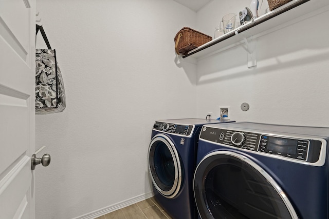 laundry room with laundry area, washing machine and dryer, baseboards, and wood tiled floor