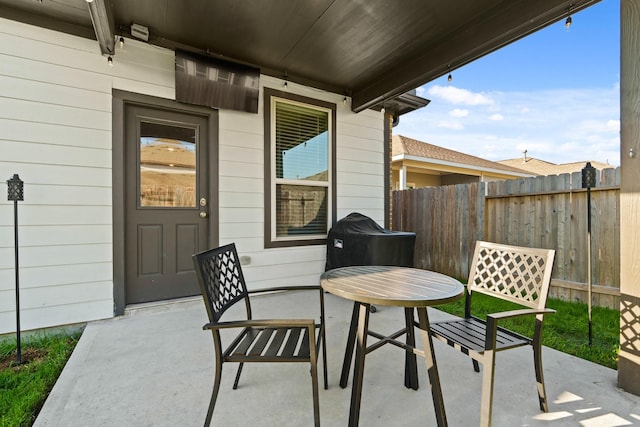 view of patio with outdoor dining space and fence