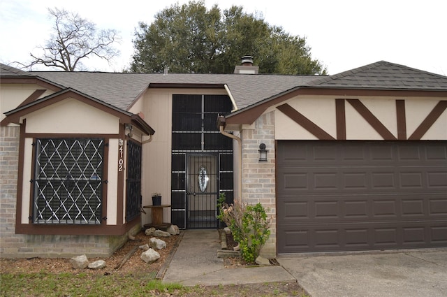 view of front of property featuring stucco siding, driveway, roof with shingles, a garage, and brick siding