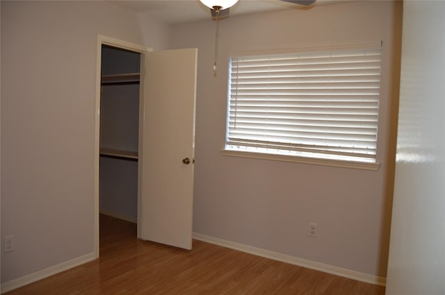 unfurnished bedroom with a closet, baseboards, and wood finished floors