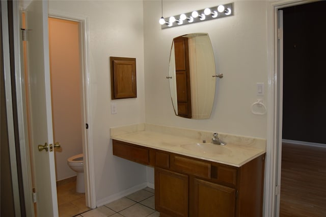 bathroom featuring tile patterned flooring, toilet, vanity, and baseboards