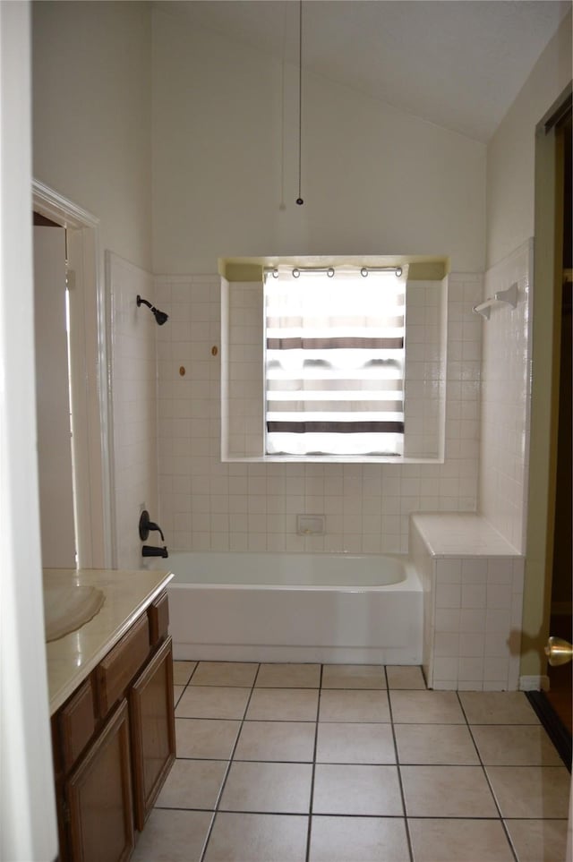 bathroom featuring vanity, lofted ceiling, shower / tub combination, and tile patterned floors