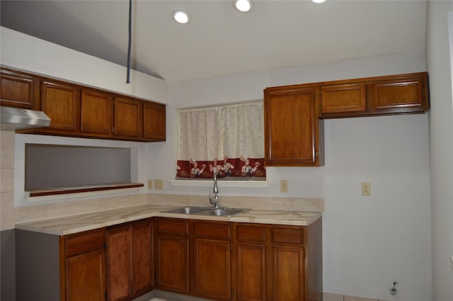 kitchen featuring brown cabinets, a sink, under cabinet range hood, recessed lighting, and light countertops