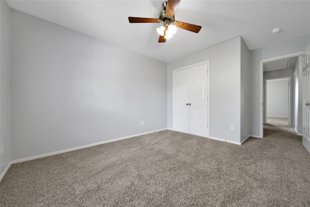 unfurnished bedroom featuring attic access, carpet flooring, baseboards, and a closet