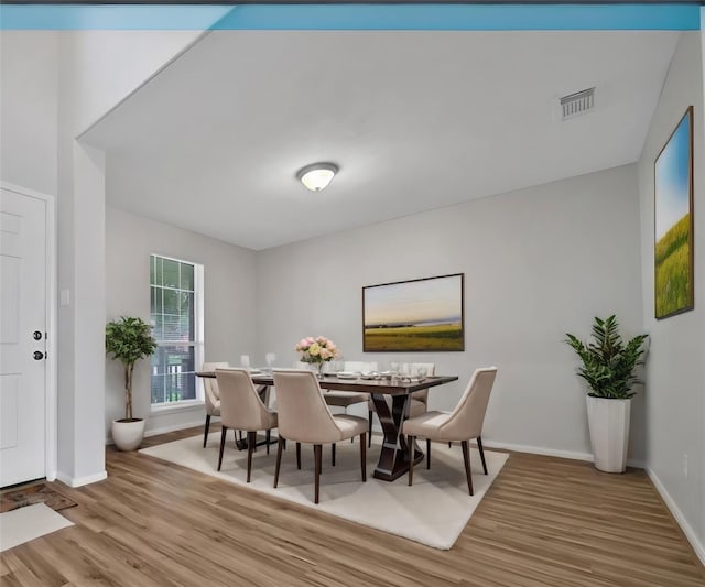 dining area featuring visible vents, baseboards, and wood finished floors