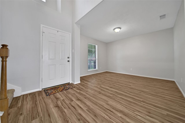 foyer entrance with wood finished floors, visible vents, and baseboards