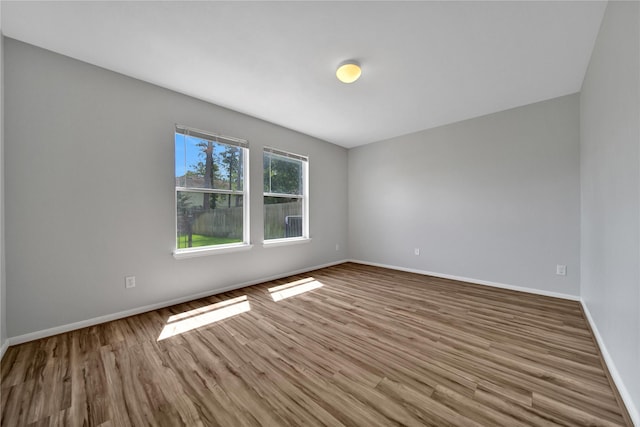 empty room with wood finished floors and baseboards