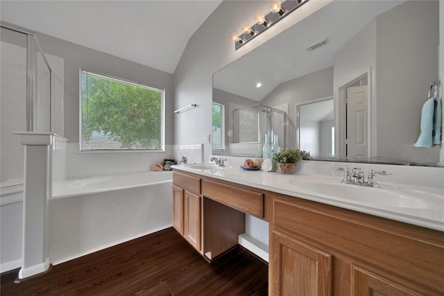 bathroom with visible vents, a stall shower, a sink, vaulted ceiling, and a garden tub