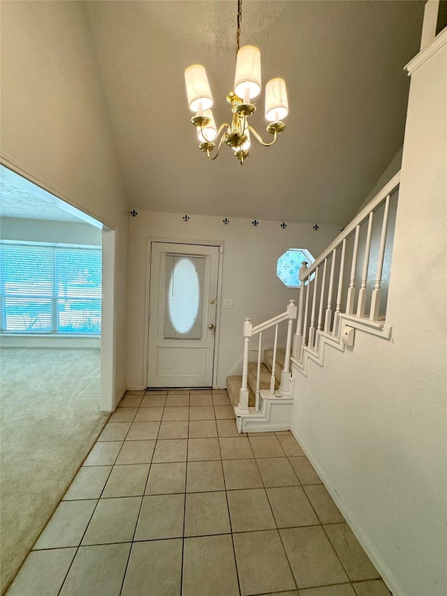 foyer with a notable chandelier, light tile patterned flooring, light colored carpet, stairs, and vaulted ceiling