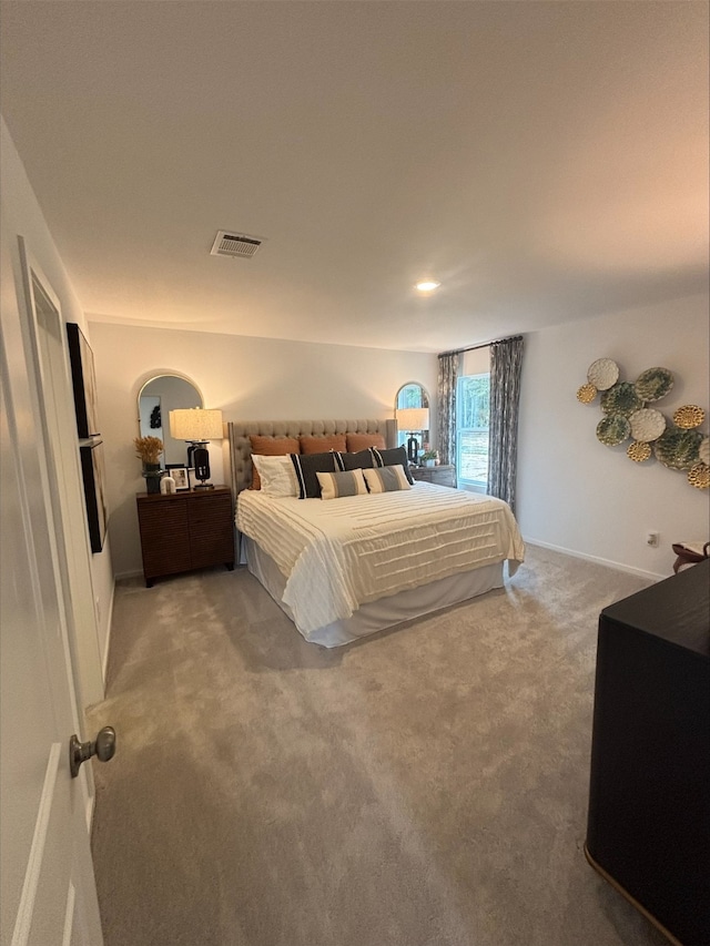 bedroom with visible vents, baseboards, and light colored carpet