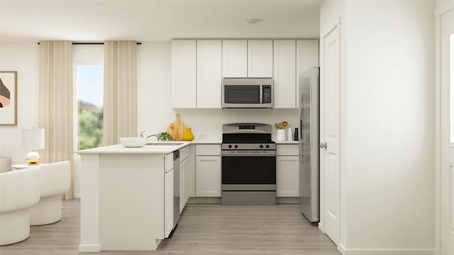 kitchen with light wood-type flooring, a sink, stainless steel appliances, a peninsula, and light countertops