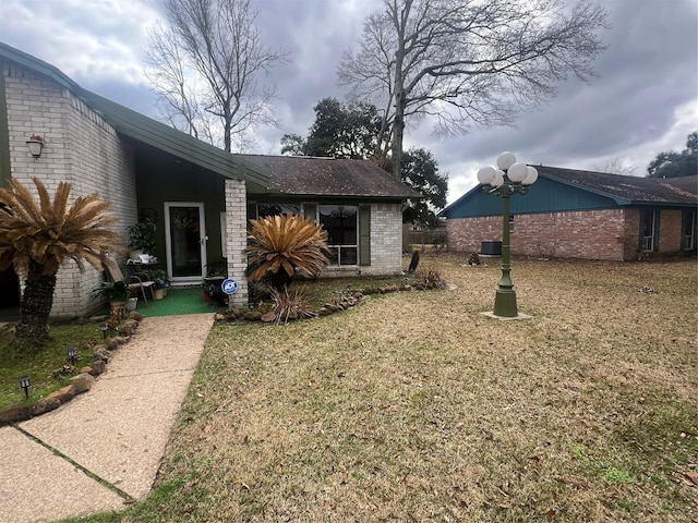 exterior space featuring a front yard and brick siding